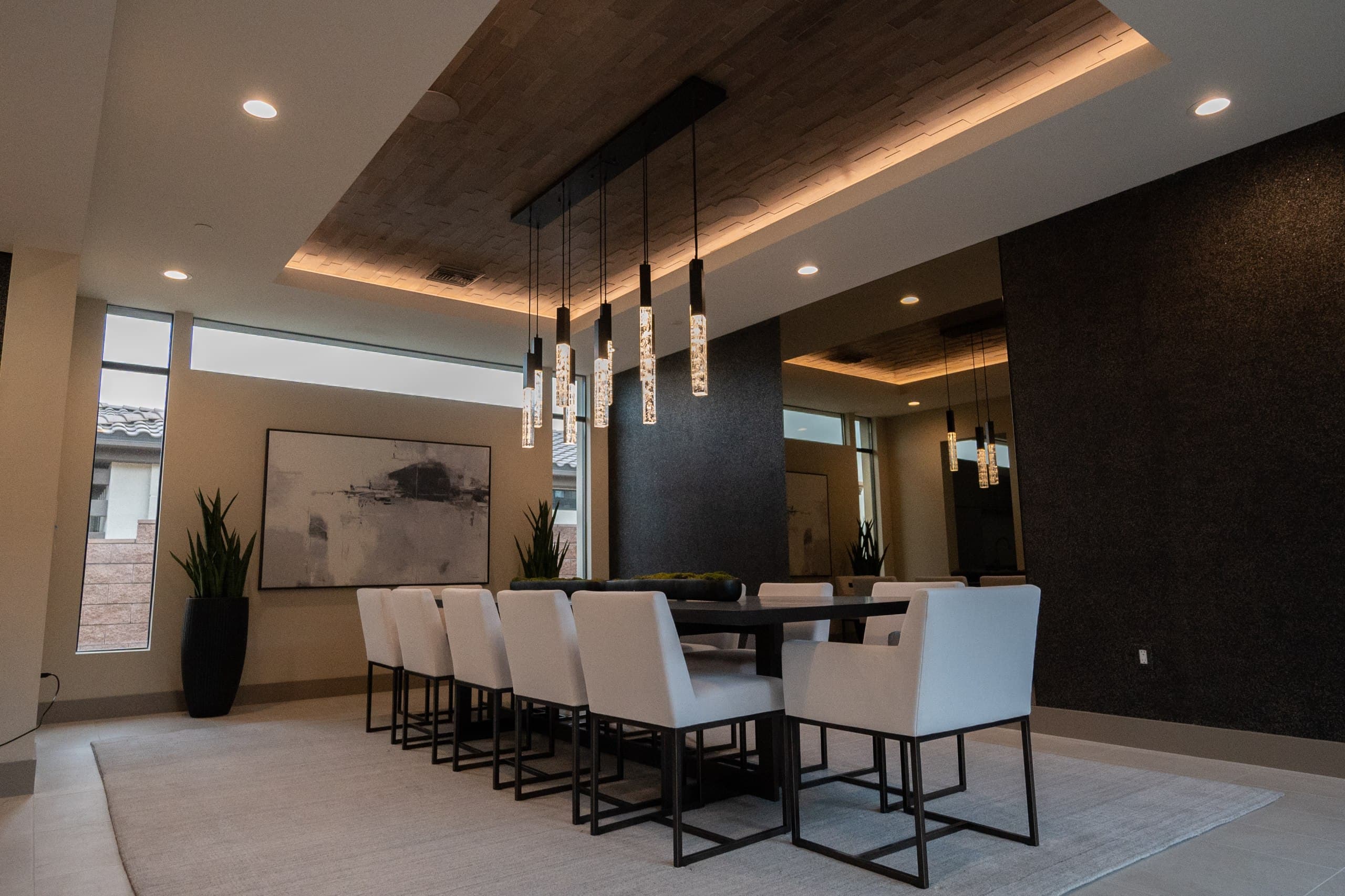 Luxury dining room with warm cove lighting, crystal pendant lights, and recessed cans