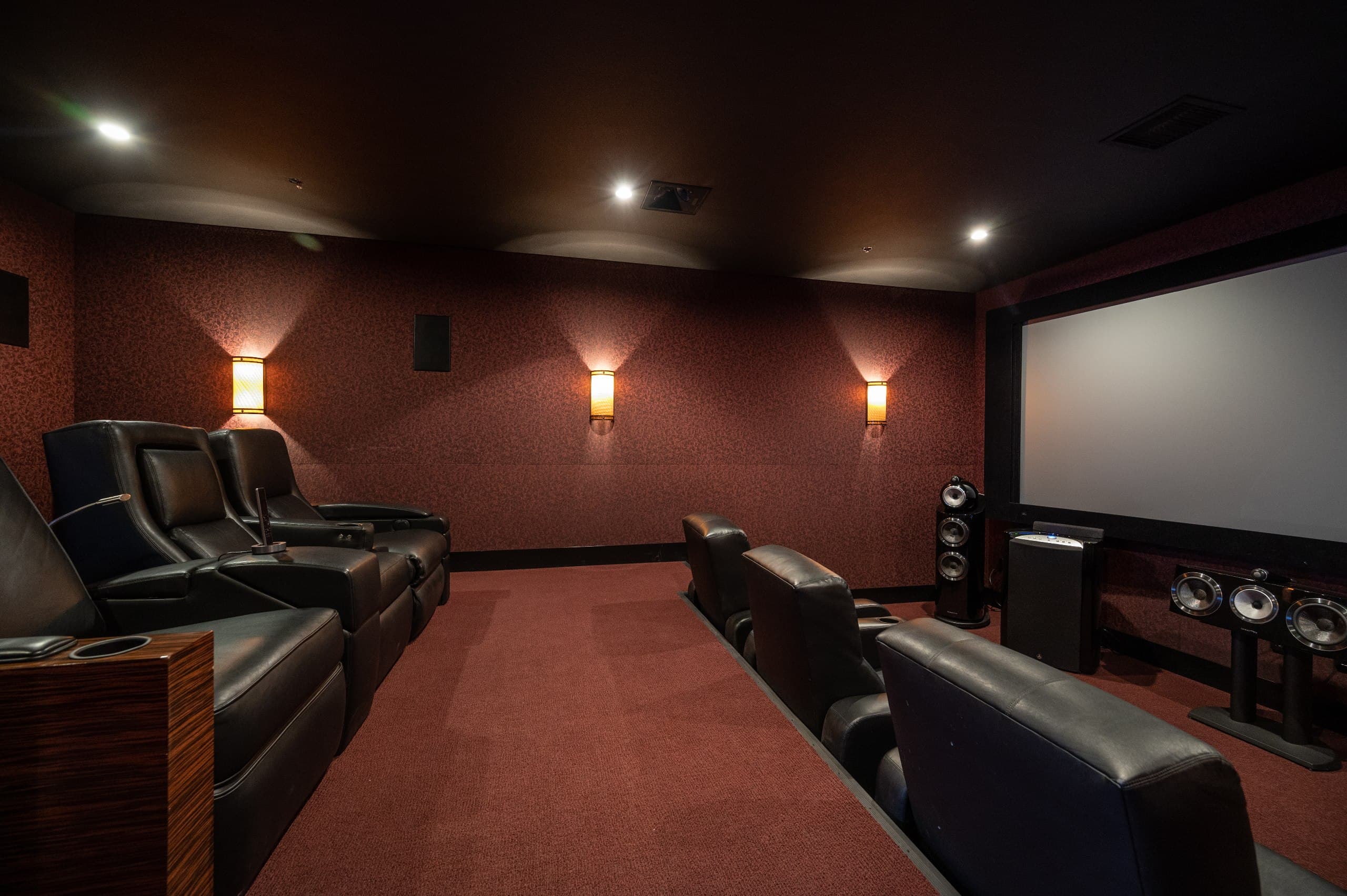 Side view of luxury home theater showing tiered recliner seating and acoustic wall treatments