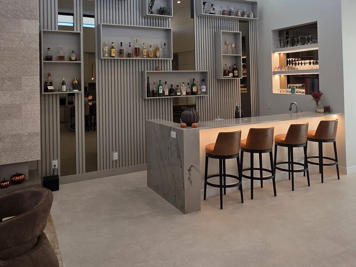 Home bar with LED lighting glowing under the counter and on the glass shelves behind it