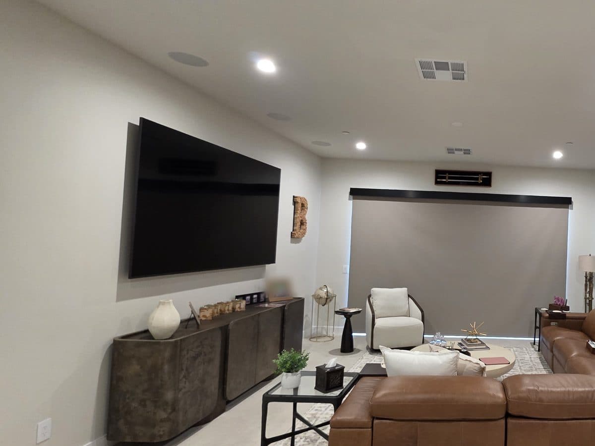 Media room with a 100-inch Samsung TV on the wall, in-ceiling speakers and the motorized shade lowered