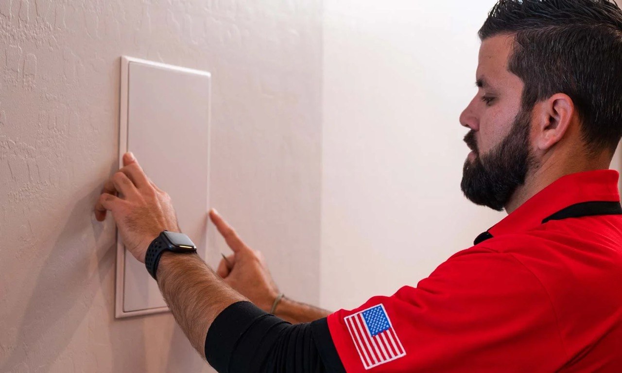 Eagle Sentry technician installing an invisible in-wall speaker in a Las Vegas home